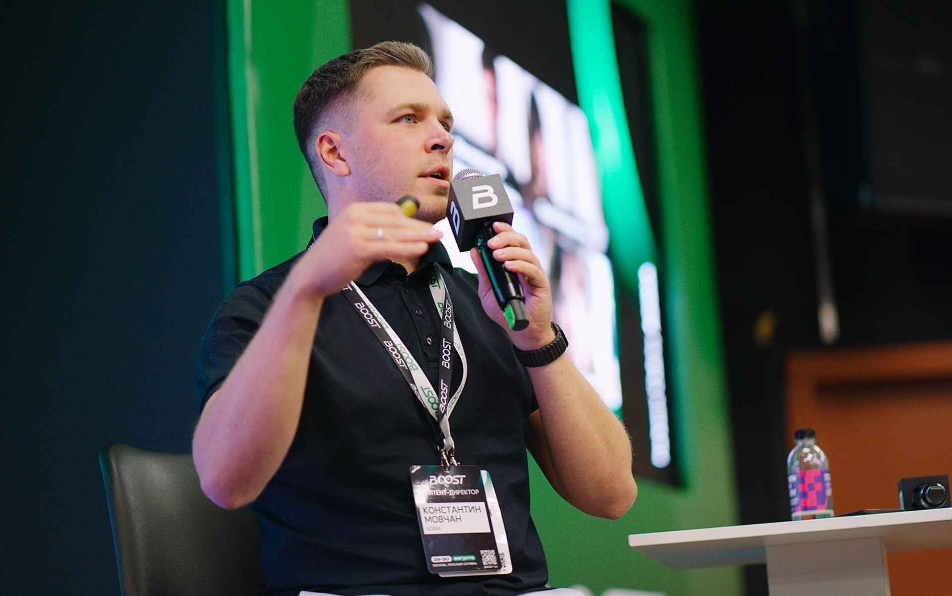 Константин Мовчан выступает с микрофоном на конференции BOOST